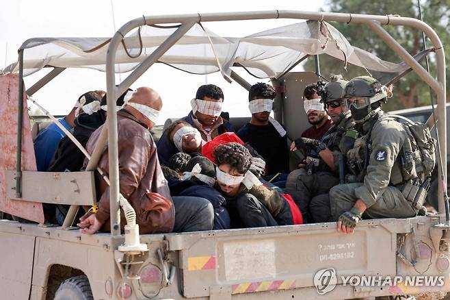 억류 팔레스타인인 이송하는 이스라엘군 (이스라엘-가자지구 국경 AFP=연합뉴스) 이스라엘 군인들이 21일(현지시간) 억류된 팔레스타인인들을 가자지구 밖으로 이송하고 있다. 외신은 이날 이스라엘과 팔레스타인 무장 정파 하마스가 수감자 150명과 인질 50명을 교환하기로 합의했다고 보도했다. 2023.11.22 besthope@yna.co.kr