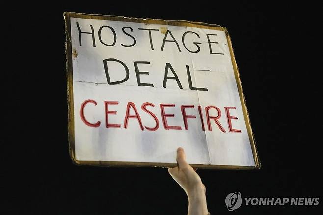 '인질 협상과 휴전' 손팻말 든 이스라엘 인질 친지들 (텔아비브 AP=연합뉴스) 팔레스타인 무장 정파 하마스가 가자지구에 억류하고 있는 인질 240여 명의 가족과 친구들이 21일(현지시간) 이스라엘 텔아비브에서 베냐민 네타냐후 총리에게 인질 석방을 위한 노력을 촉구하는 시위를 벌이고 있다. 이날 이스라엘 각료회의는 인질 50여명의 석방을 조건으로 4일간 교전을 중지하는 내용의 협상안을 승인했다. 2023.11.22 besthope@yna.co.kr