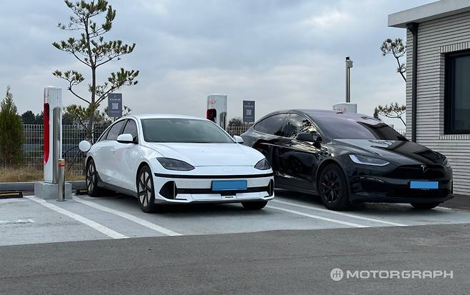 아이오닉6와 모델Y가 슈퍼차저에서 나란히 충전 중이다