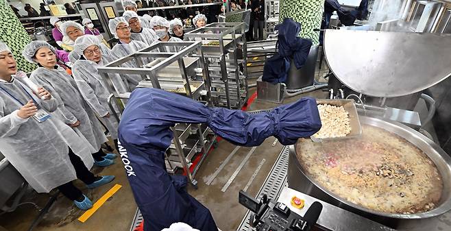 A robot designed to perform culinary tasks prepares school meals for 730 people, including students and school staff members, at Soonggok Middle School in Seongbuk-gu, northern Seoul. (Joint Press Corps)