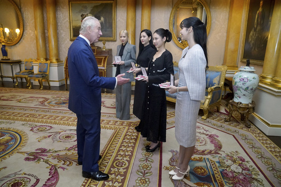 Britain's King Charles III, left. presents the members of the K-Pop band Blackpink with MBEs, Member of the Order of the British Empire at Buckingham Palace, in London, Wednesday, Nov. 22, 2023. [AP/YONHAP]