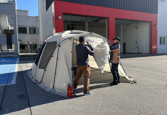 ▲ 화로에 숯을 태워 텐트 내부에서 10분간 방치한 뒤 경고음이 울리자 텐트문을 개방하고 있다.