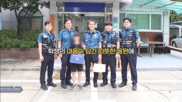 초등학교 4학년 학생 A군이 1년 동안 모은 용돈으로 간식을 마련해 경찰 지구대에 전달했다. 사진은 A군이 경찰들에게 간식을 전해주고 함께 사진을 찍고 있는 모습. /사진='경찰청' 유튜브