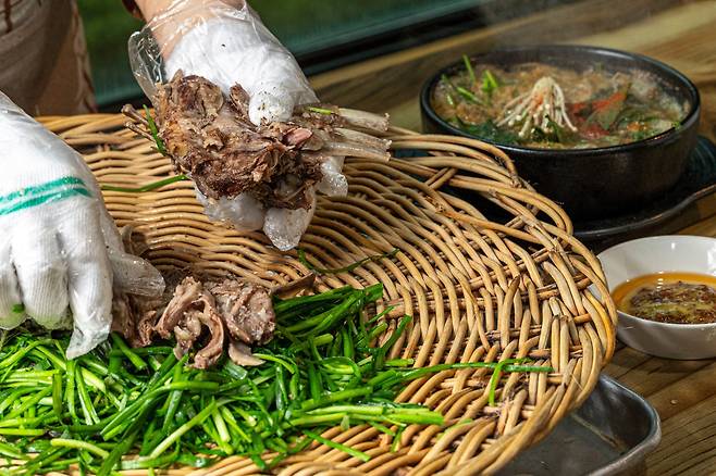 경기도 하남 ‘까치산장’ 주인 차형자씨가 흑염소 배받이와 갈비 수육을 손으로 찢고 있다./이신영 영상미디어 기자