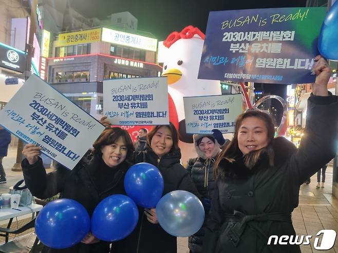 부산시민들이 부산엑스포 유치를 염원하는 문구가 적힌 종이 팻말을 들고 응원 열기를 더하고 있다./뉴스1 이현동 기자