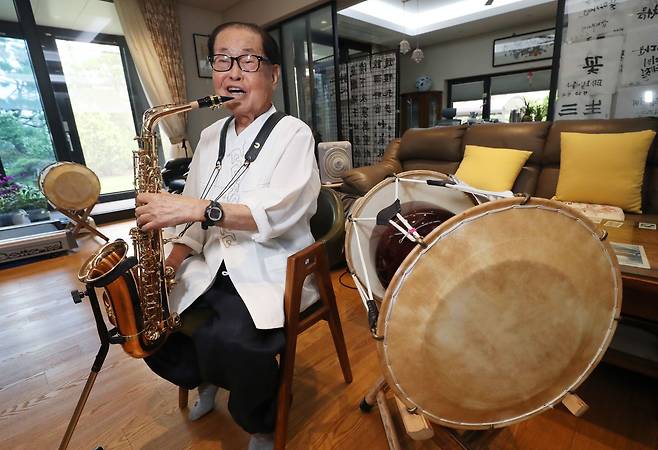 올해 95세인 김안과 병원 이사장은 80대 중반 넘어 색소폰, 장구 등 다양한 악기를 배우고 연주하며 건강을 다진다. 서예도 늦은 나이에 입문했는데, 거실 뒤편에 그가 쓴 작품이 걸려 있다. /신현종 기자