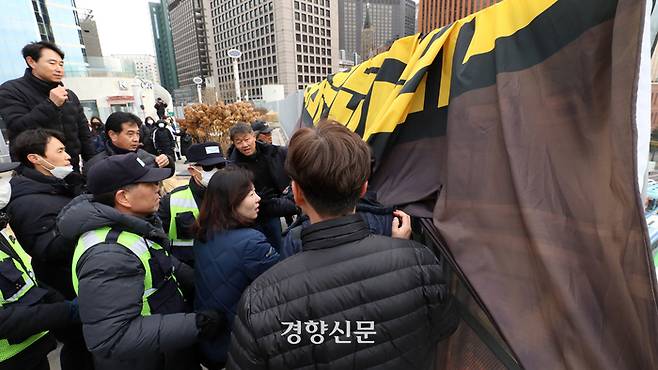 국민건강보험공단고객센터 노동조합 관계자들이 23일 서울 중구 서울로7017에서 공단 측에 정규직 전환 합의 이행을 촉구하며 기습 선전전 중 현수막 제거 여부를 놓고 경찰과 충돌하고 있다. 2023.11.29 권도현 기자