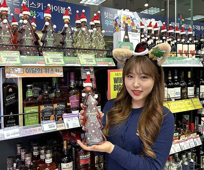 GS25에서 모델이 모젤크리스마스 와인을 들고 포즈를 취하고 있다. [GS25 제공]