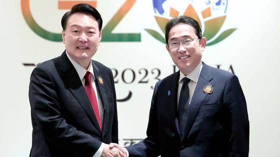 President Yoon Suk Yeol, left, Japanese Prime Minister Fumio Kishida, shake hands during the G20 meeting held in India in September. [YONHAP]