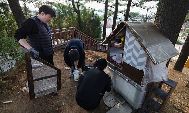 더불어민주당 한정애 의원실 보좌진이 서울 여의도 국회의 길고양이 집을 겨울나기용으로 교체하고 사료와 물을 보충하고 있다.