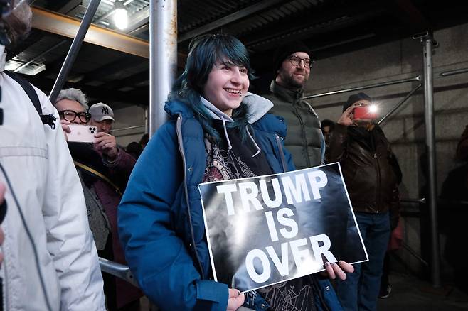 트럼프 기소 소식이 알려진 3월30일 기소에 찬성하는 시민들이 대배심이 열린 맨해튼 법원 앞에서 '트럼프는 끝났다'는 피켓을 들고 환영 집회를 벌이고 있다.  /AFP 연합뉴스