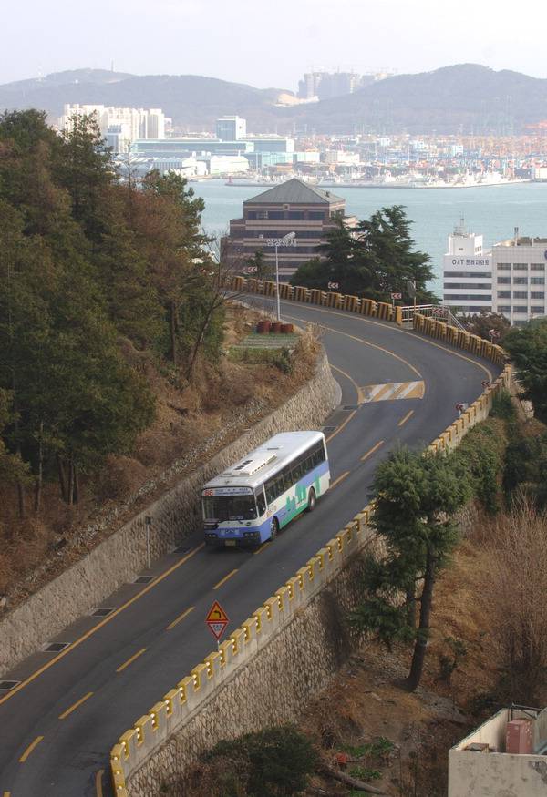영주동 산복도로를 운행 중인 시내버스 뒤로 부산항이 보인다.  국제신문DB