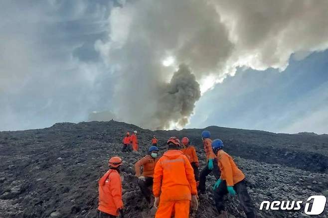 4일(현지시간) 구조대원들이 인도네시아 수마트라섬 서부 므라피산 화산 폭발 현장에서 희생자들을 피난시키고 있다. 2023.12.04 ⓒ AFP=뉴스1 ⓒ News1 정지윤 기자