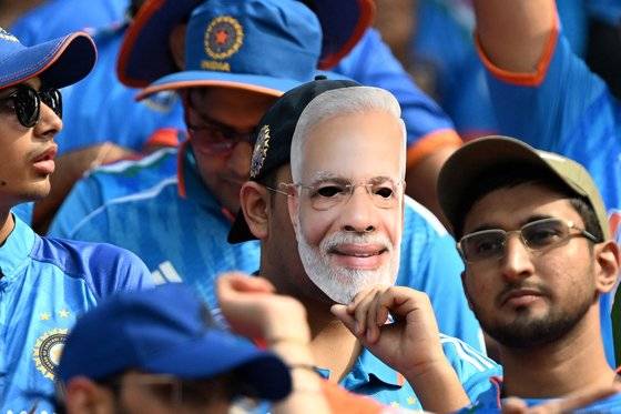 인도 구자라트주 아메다바드의 나렌드라모디 스타디움에서 관중석에 있는 크리켓 팬이 모디 총리의 가면을 쓰고 경기 시작을 기다리고 있다. AFP=연합뉴스