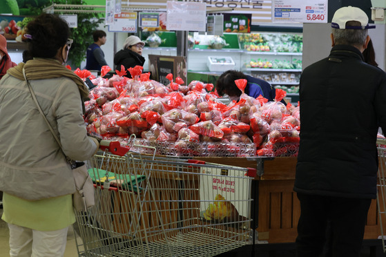 Customers shop for apples at a supermarket in Seoul on Tuesday. Korea's consumer prices grew 3.3 percent in November from a year earlier, led by agricultural products. Apple prices soared 55.5 percent, while tangerines jumped 16.7 percent over the same period. [YONHAP]