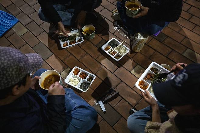 11월21일 저녁 서울도시가스 본사 앞에서 퇴근 후 달려 온 도시가스 점검원들이 밥통이 준비한 밥을 먹고 있다. ⓒ시사IN 신선영