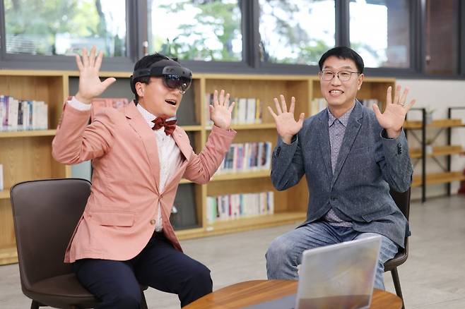 본보 이진한 의학전문기자(왼쪽)가 복합현실(MR) 기술을 활용한 상지운동 재활 운동을 체험하고 있다. 고큐바 테크놀로지의 진훈 CTO(최고기술경영자)가 옆에서 이용 방법에 대해 설명해주고 있다. 서울바이오허브 제공