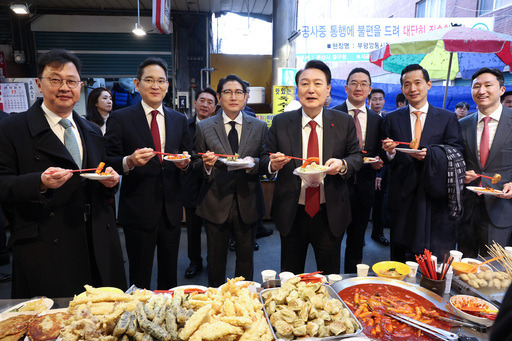 윤석열 대통령이 6일 부산 중구 깡통시장을 방문해 재계 총수들과 함께 떡볶이를 맛보고 있다. 앞줄 왼쪽부터 최재원 SK 수석부회장, 이재용 삼성전자 회장, 조현준 효성그룹 회장, 윤 대통령, 구광모 LG그룹 회장, 김동관 한화그룹 부회장, 정기선 HD현대 부회장. 부산=뉴시스