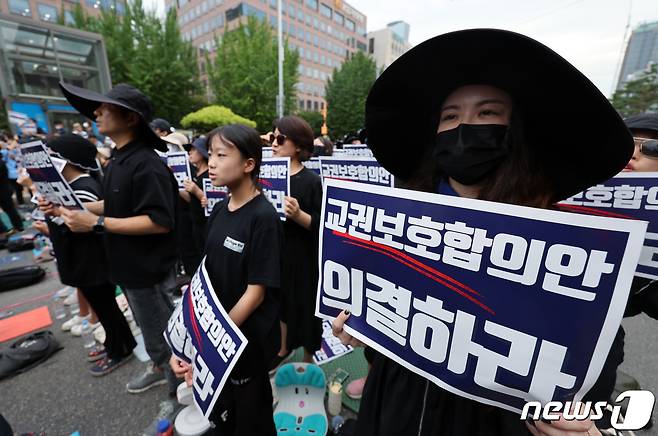 사망한 서이초 교사의 49재이자 '공교육 멈춤의 날'인 4일 오후 서울 여의도 국회의사당 앞에서 열린 서이초 교사 49재 추모집회에서 참석자들이 손피켓을 들어 구호를 외치고 있다. 국회 앞에 모인 교사와 시민들은 극단적 선택을 서이초 교사 진상규명과 5개 교원단체가 합동 발표한 ‘교원보호 입법발의 공동안’ 의결, 안전하고 존중받는 교육환경 조성 등을 촉구했다. 2023.9.4/뉴스1 ⓒ News1 박정호 기자