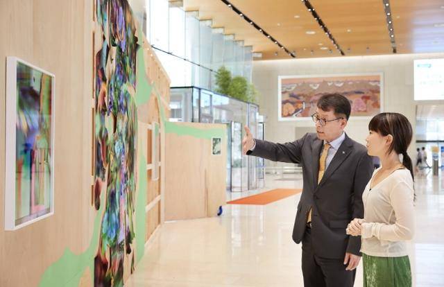 지난 7월 서울 중구 을지로 IBK기업은행 본점에서 김성태(왼쪽) IBK기업은행장과 오가영 작가가 작품에 관해 이야기를 나누고 있다. IBK기업은행