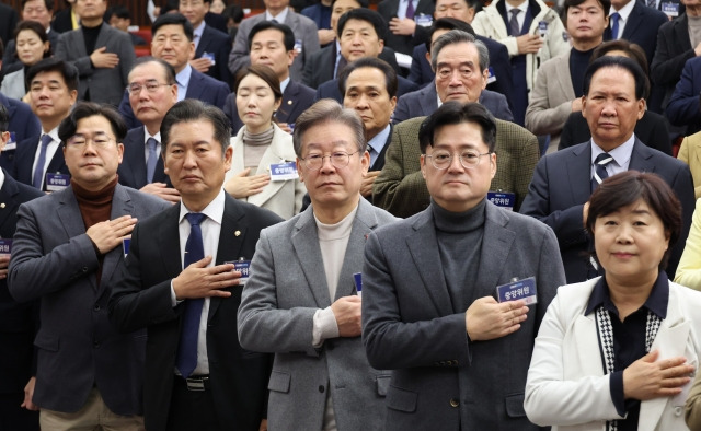 더불어민주당 이재명 대표와 홍익표 원내대표, 최고위원들이 7일 국회에서 열린 중앙위원회의에서 국민의례를 하고 있다. 연합뉴스