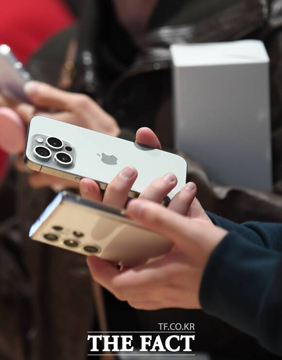 '애플 하남' 매장을 찾은 한 방문객이 자신의 삼성폰과 아이폰 제품을 비교해 살펴보고 있다.