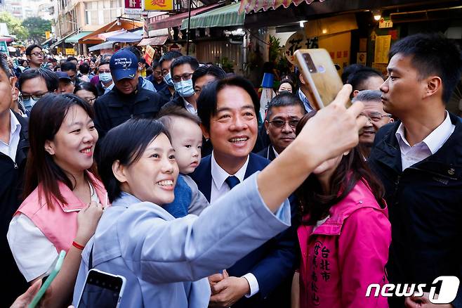 대만 집권당인 민진당 총통 후보인 라이칭더 부총통이 7일(현지시간) 대만 타이베이에서 지지자들과 사진을 찍고 있다. 대만 총통 선거는 내년 1월 13일에 실시될 예정이다. 23.12.07 ⓒ 로이터=뉴스1 ⓒ News1 김예슬 기자