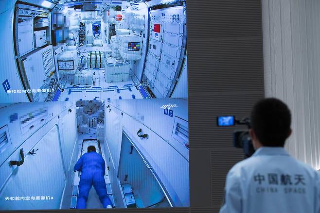 17일 유인 우주선을 타고 올라간 중국 우주인이 텐허 우주정거장 모듈에 성공적으로 진입하는 장면을 지상 우주센터에 있는 과학자가 모니터로 지켜보고 있다./신화/AP 연합뉴스