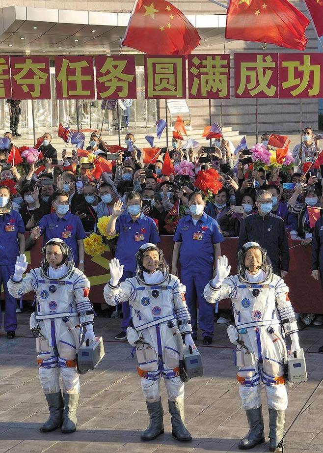17일 중국 간쑤성 주취안 기지에서 열린 선저우 12호 발사 출정식에서 우주인 3명이 탑승에 앞서 손을 흔들어 보이고 있다. 왼쪽부터 탕훙보, 류보밍, 녜하이성. /AP 연합뉴스