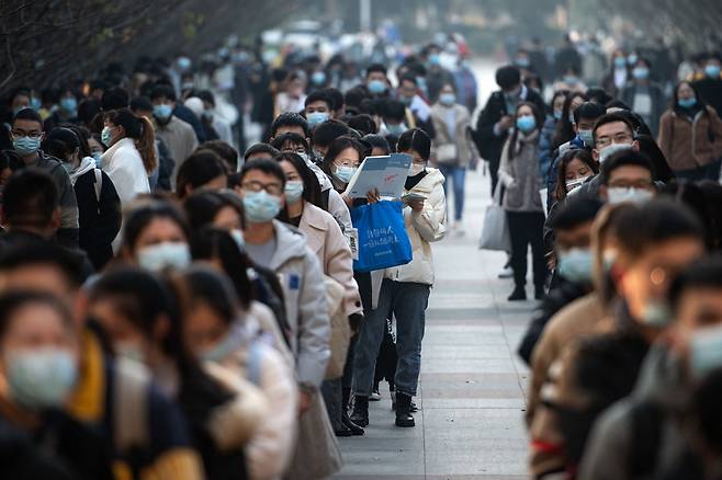 28일 중국 후베이성 우한시에서 국가공무원 시험 응시자들이 시험장에 입실하기 위해 줄을 서고 있다./AFP 연합뉴스