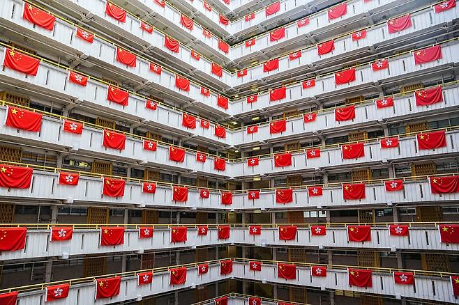 26일 홍콩의 한 아파트에 중국 국기와 그보다 작은 크기의 홍콩 특구 깃발이 걸려있다. 시진핑 중국 국가주석은 오는 7월 1일 홍콩에서 열리는 홍콩 반환 25주년 기념식에 참석한다. /로이터 연합뉴스