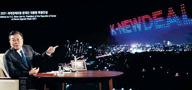 문재인 대통령이 27일 청와대에서 화상으로 열린 ’2021 세계경제포럼(WEF)’ 특별연설에서 상영 중인 자료 영상을 보며 대화하고 있다. /연합뉴스