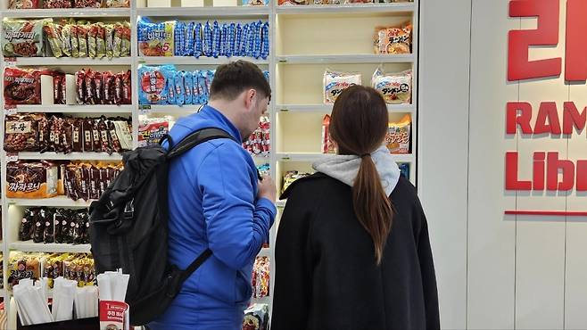 외국인 관광객들이 서울 서교동 CU홍대상상점의 라면 진열대에서 라면을 고르고 있다./ 김동주 기자