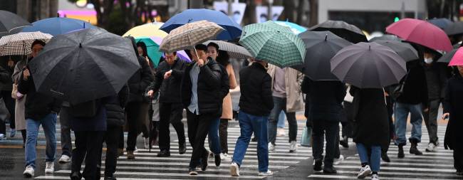 겨울에 만난 ‘호우’ 전국 대부분 지역에 많은 양의 겨울비가 내리는 11일 오전 서울 광화문 사거리에서 시민들이 우산을 쓰고 걸어가고 있다. 박윤슬 기자