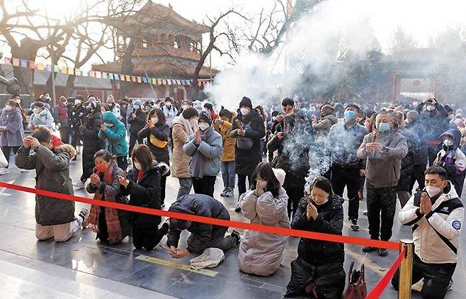 중국 최대 명절인 춘제(春節)를 맞아 지난 22일 베이징 시내 라마교 사원에서 시민들이 신년 기도를 하고 있다. ‘제로 코로나’ 규제가 풀린 뒤 첫 춘제 연휴를 맞아 도심 곳곳이 인파로 붐볐다. /로이터 뉴스1