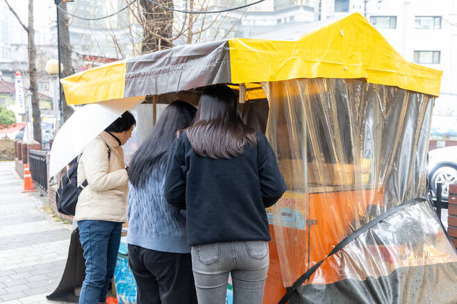 2023년 12월6일 서울 마포구의 한 포장마차 앞에서 잉어빵을 기다리는 손님들이 서 있다. 박승화 기자