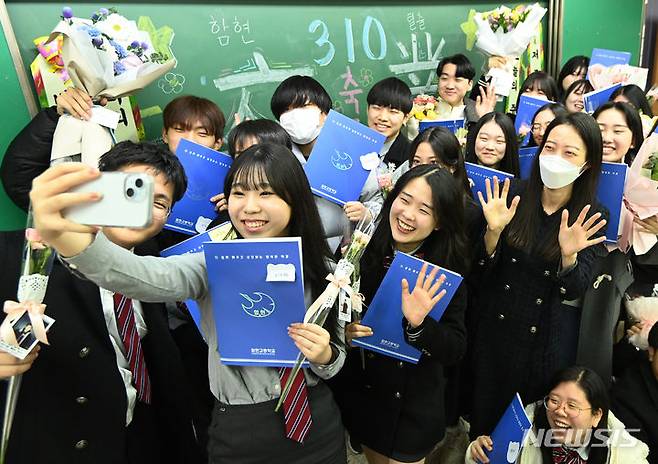 [시흥=뉴시스] 김종택 기자 = 12일 경기도 시흥시 함현고등학교에서 열린 졸업식에서 학생들이 선생님과 함께 기념촬영 하며 추억을 남기고 있다. 2023.12.12. jtk@newsis.com