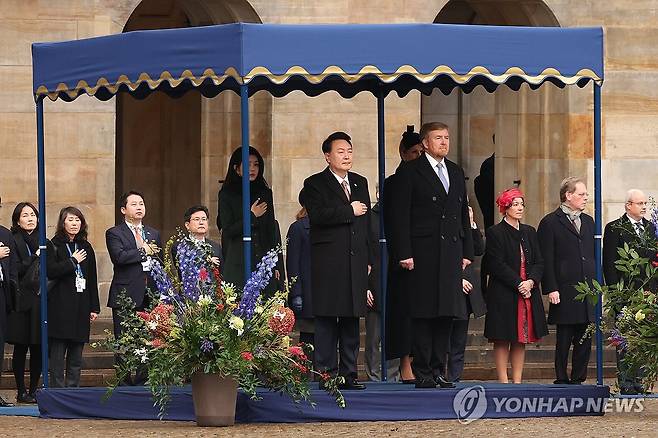 윤석열 대통령 내외, 네덜란드 국빈 방문 공식 환영식 (암스테르담=연합뉴스) 진성철 기자 = 윤석열 대통령과 부인 김건희 여사가 12일(현지시간) 암스테르담 담 광장에서 열린 공식 환영식에서 빌럼-알렉산더르 네덜란드 국왕, 막시마 왕비와 함께 양국 국가가 연주되는 동안 국민의례를 하고 있다. 2023.12.12 zjin@yna.co.kr