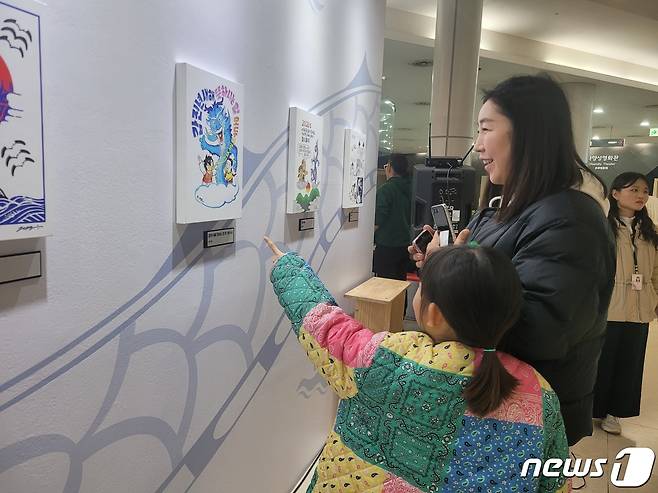 12일 경기 부천시 한국만화박물관에서 열린 ‘행복하세龍(용)’ 새해카툰전에 방문한 함소연씨가 딸 용태은양과 함께 작품을 관람하고 있다./ 뉴스1 ⓒ News1 이시명기자