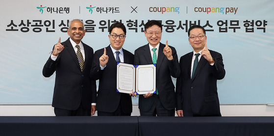 Hana Bank CEO Lee Seung-lyul, second from right, and Coupang CEO Kang Han-seung, second from left, pose for a photo at the signing of their partnership at Coupang's headquarters in Songpa District, southern Seoul, on Tuesday. [HANA BANK]