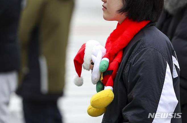 [서울=뉴시스] 정병혁 기자 = 쌀쌀한 날씨를 보인 지난 12일 서울 종로구 광화문광장에서 산타 목도리를 한 시민이 신호를 기다리고 있다. 2023.12.12. jhope@newsis.com