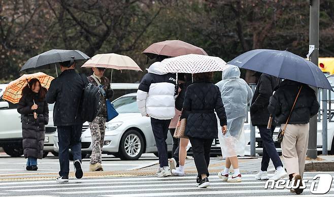 겨울비가 내리는 14일 오전 서울 송파구 잠실역 인근에서 우산을 쓴 시민들이 발걸음을 재촉하고 있다. 2023.12.14/뉴스1 ⓒ News1 김도우 기자