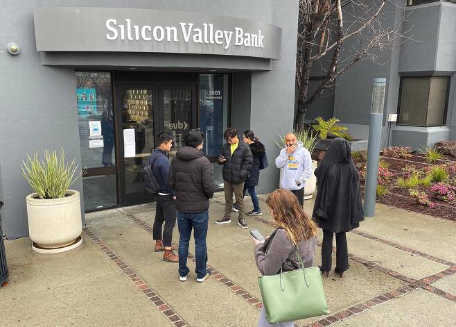 지난 10일(현지 시각) 미국 캘리포니아주 샌타클래라에 있는 실리콘밸리뱅크(SVB) 앞에 시민들이 서 있는 모습. 이날 캘리포니아주 금융 당국은 지급 불능 등을 이유로 SVB를 폐쇄한다고 발표했다. /AFP 연합뉴스