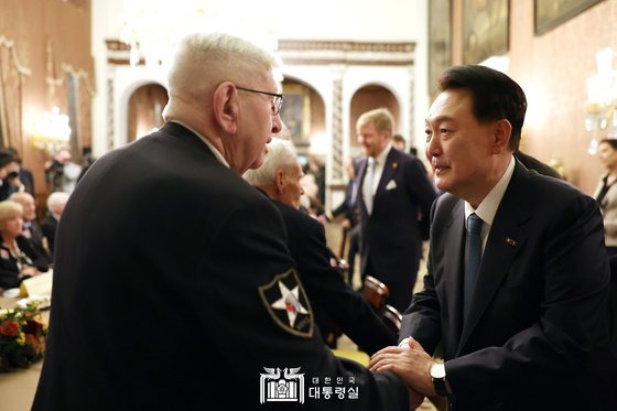 네덜란드 국빈 방문 중인 윤석열 대통령이 13일 오후(현지시간) 암스테르담 왕궁 쓰론룸에서 열린 한국전 참전용사 간담회에서 참석자들과 악수하고 있다. 뉴스1