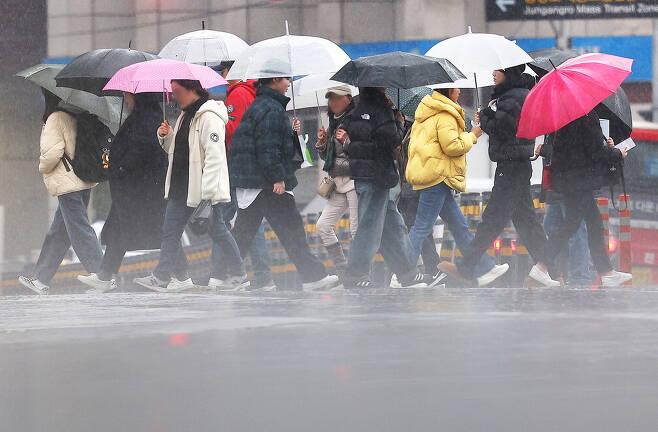 전국에 걸쳐 비와 눈이 '겨울 장마'처럼 내리고 있는 가운데 14일 대구 중구 동성로에서 시민들이 빗속을 걷고 있다.  연합뉴스
