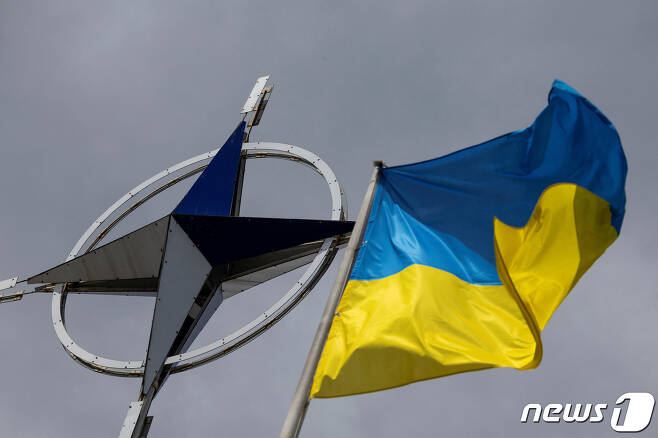 11일(현지시간) 우크라이나 키이우 중심가에서 북대서양조약기구(NATO·나토)를 상징하는 로고 옆에 우크라이나 국기가 게양돼 있다. 2023.07.11/ ⓒ 로이터=뉴스1 ⓒ News1 권진영 기자