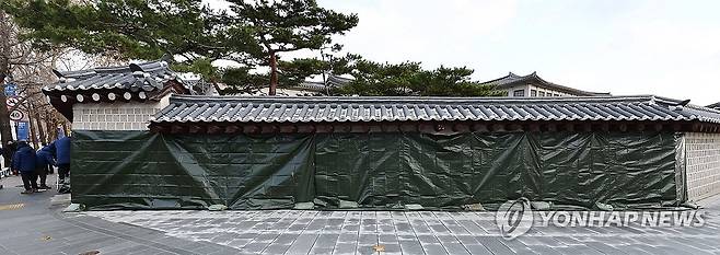 경복궁 담벼락에 스프레이 낙서 (서울=연합뉴스) 김인철 기자 = 16일 오전 서울 종로구 경복궁 서쪽 담벼락에 누군가 스프레이로 낙서한 부분이 천막으로 가려져 있다. 2023.12.16 yatoya@yna.co.kr