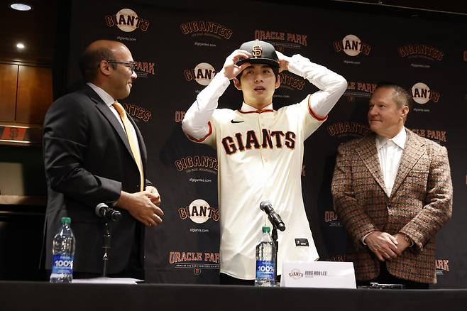 이정후가 파란 자이디 사장, 에이전트 스캇 보라스가 보는 가운데 모자를 써보고 있다. EPA연합뉴스