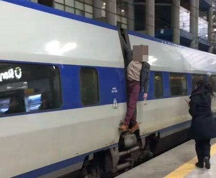 막 출발한 KTX 열차에 매달린 외국인 남성과, 이를 저지하고 있는 역무원. /유튜브