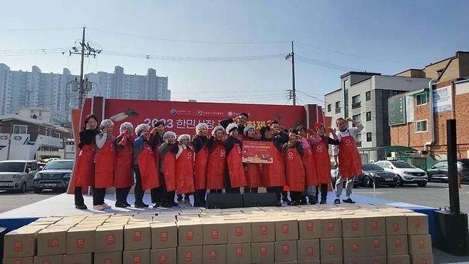 지난달 23일 한민시장 제2주차장에서 진행된 김장문화축제에서 상인과 주민 등 축제 참가자들이 완성된 김치를 소외이웃들에게 전달하기에 앞서 기념촬영을 하고 있다. 한민시장 제공